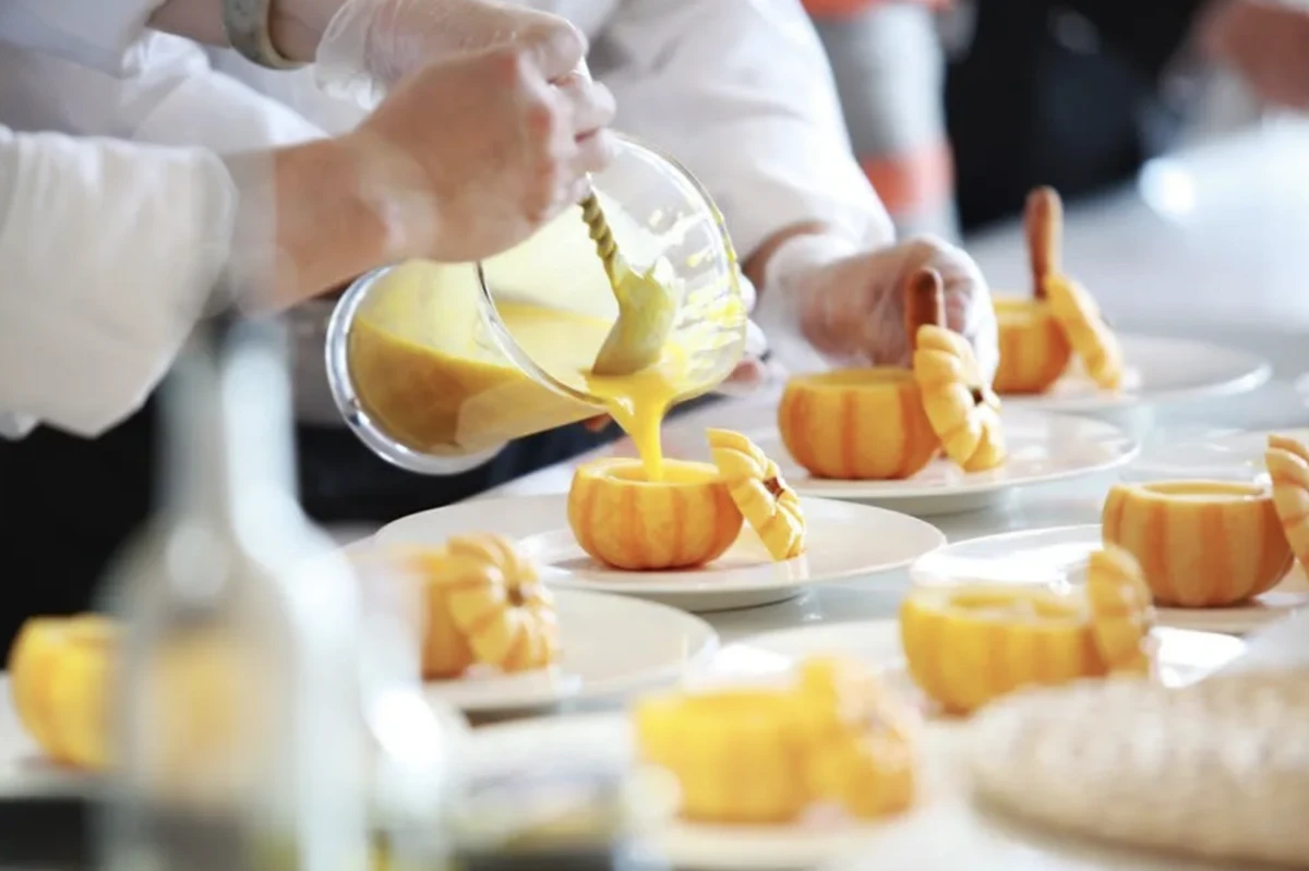 Cours de cuisine parents enfant, main qui verse un liquide dans un fruit